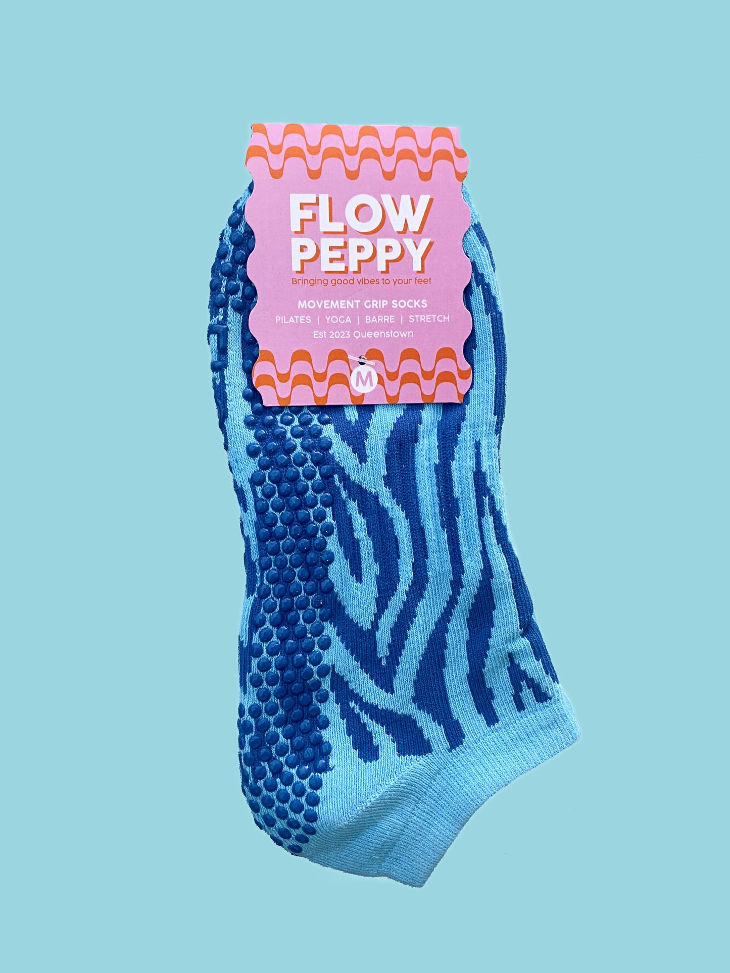 Blue pair of Flow Peppy, New Zealand made ankle pilates and yoga grip socks blue patterns.